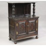 A 19th century Carolean Revival stained oak side cupboard, the shelf top above a pair of carved