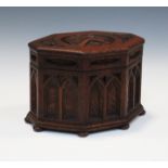 An early 20th century Gothic Revival oak octagonal musical casket, the hinged lid carved with an