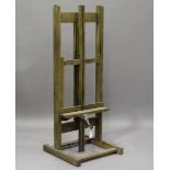 A mid-20th century limed oak artist's easel with chain-driven rising mechanism, height 165cm,