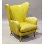 A mid-20th century wing back armchair by Howard Keith, raised on tapering legs, height 100cm,