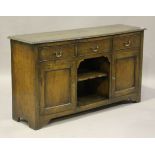 An 18th century style oak dresser base, the three drawers above an open shelf flanked by