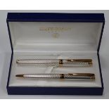 A Waterman silver and gilt metal pen set, comprising roller ball and ballpoint, cased.Buyer’s