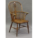 A mid-Victorian ash and elm stick and wheel back Windsor armchair, the shaped seat panel on turned