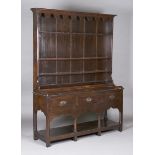 A late 18th century provincial oak dresser, the shelf back above a raised gallery and three drawers,