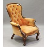 A mid-Victorian walnut showframe salon armchair with a foliate carved crest and cabriole legs,