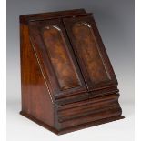 A mid-Victorian mahogany slope-fronted stationery box, the two arched panel doors enclosing a letter