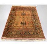 An Afghan rug, mid/late 20th century, the shaded chestnut field with angular medallions and floral