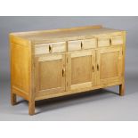 An early 20th century Heals pale oak sideboard, fitted with three drawers above panelled cupboard