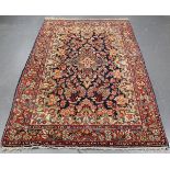 A Central Persian rug, mid-20th century, the ink blue field with a flowering medallion, supported by