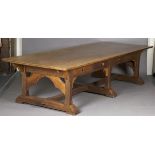 A large early 20th century Arts and Crafts oak refectory table, the rectangular top above eight