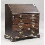 A George III oak bureau, the fall-flap above two short and three long drawers, on bracket feet,