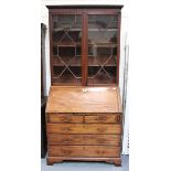 A George III mahogany bureau bookcase, the fall-flap enclosing a fitted interior, height 216cm,