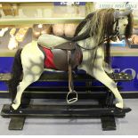 A Hadon dapple grey rocking horse with amber and black eyes, mane, tail and leather saddle and