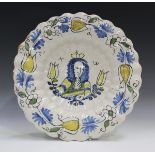 A Dutch Delft royal portrait dish, late 17th century, of circular shape, moulded with two rows of