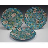 Three Longwy Cloisonné Ware faience dishes, circa 1900, with low relief floral decoration against