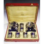 An Aynsley cobalt blue ground set of six coffee cans and saucers with gilt overlaid decoration, held