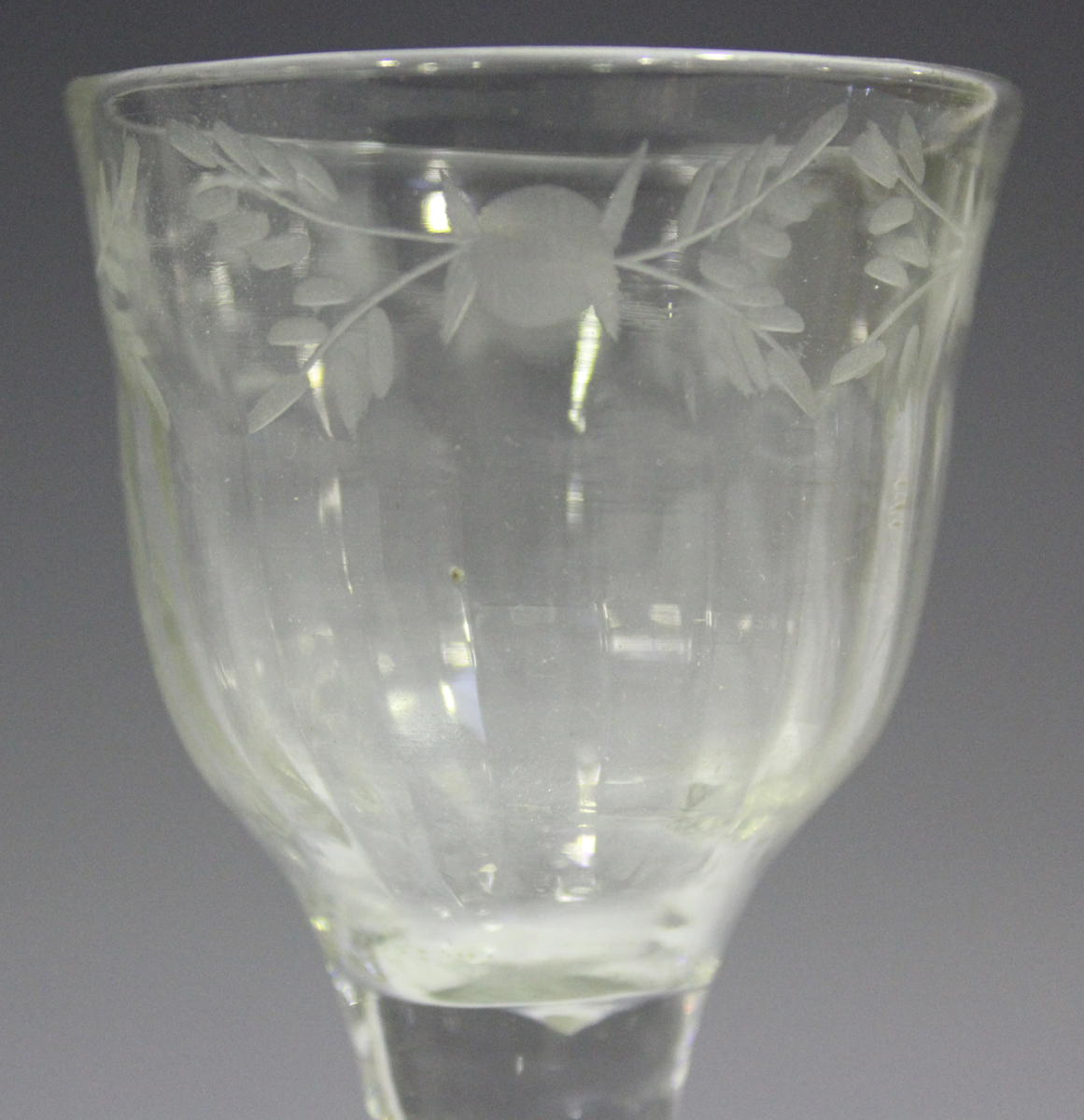 A plain stem wine glass, mid-18th century, the basal fluted ogee bowl engraved with a foliate - Image 3 of 3
