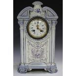 A Gien faience mantel clock, circa 1900, the white enamel dial within a laurel surround held