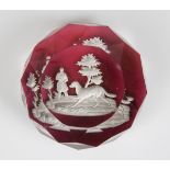 A Baccarat glass Hunter and Dog sulphide paperweight, circa 1850, set on a translucent cranberry