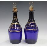 A pair of 'Bristol' blue glass club shaped decanters, early 19th century, gilt with labels inscribed