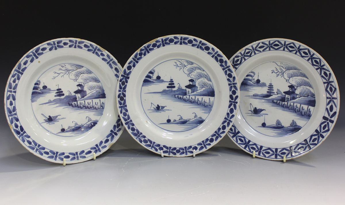 Three English Delft plates, mid-18th century, each painted in blue with a chinoiserie landscape