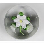 A St. Louis glass clematis paperweight, circa 1850, the white flower on a stem with five green