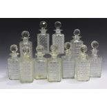 Eleven assorted cut glass decanters of square section with faceted stoppers, height of tallest