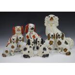 A mixed group of nine Staffordshire pottery spaniels, late 19th century, including two pairs with