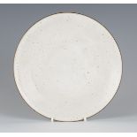 A Lucie Rie and Hans Coper studio pottery stoneware plate, covered in a speckled white glaze with
