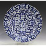 A Dutch Delft charger, 18th century, painted in blue with a central circular panel of a putti