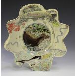 A Maureen Minchin studio pottery footed dish with wavy rim, decorated with an otter, fish and heron,
