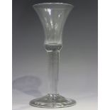 A plain stem wine glass, mid-18th century, the flared trumpet bowl raised on a plain stem on a