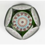 A Baccarat glass faceted green overlay patterned millefiori paperweight, circa 1850, set with a