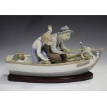 A large Lladro figure group, Fishing with Gramps, model No. 5215, length 39cm, with wood stand,