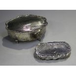 A George V silver trinket box of shaped oval form with engine turned decoration, raised on scroll
