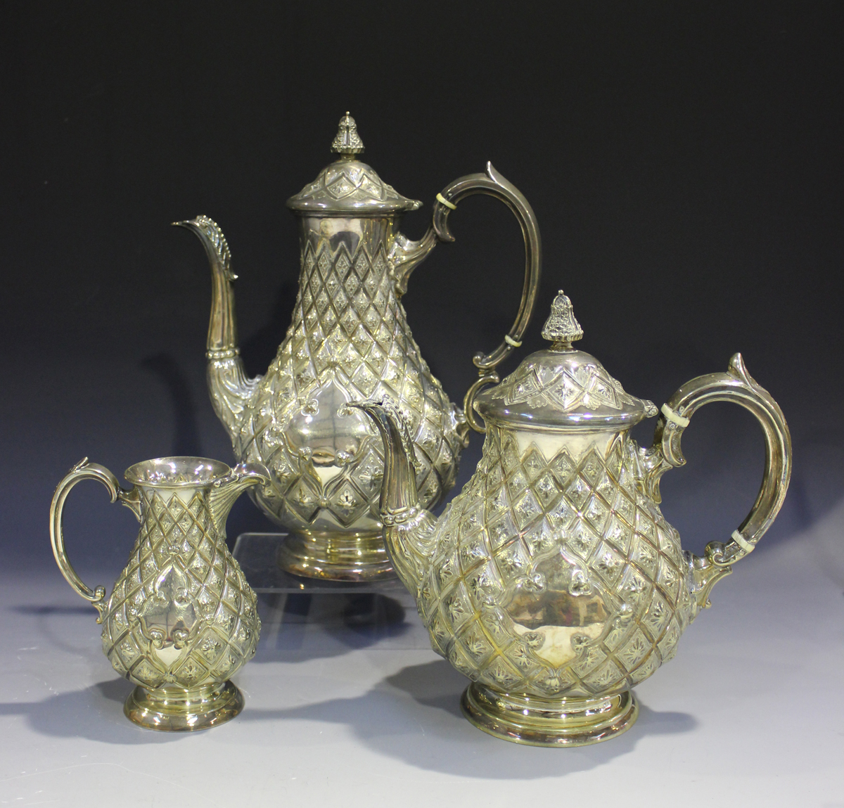 A Victorian plated three-piece tea set of pineapple moulded baluster form, comprising teapot, hot