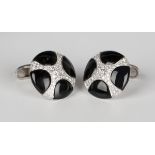 A pair of white gold, black onyx and diamond dress cufflinks, each circular front with a curved