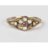 A Victorian gold ring, mounted with a central pink sapphire within a surround of half-pearls between