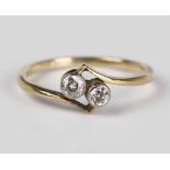 A gold and diamond two stone ring, collet set with cushion cut diamonds in a crossover design,