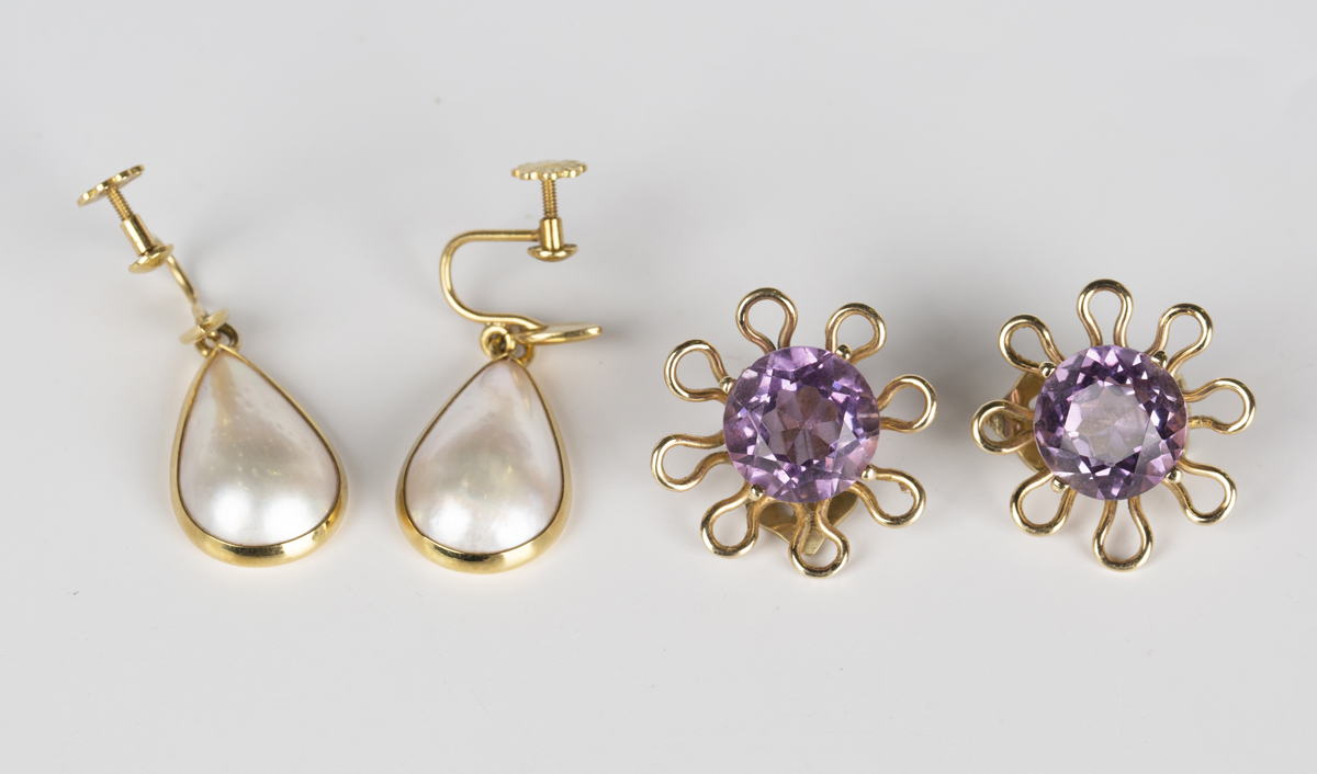 A pair of amethyst single stone earclips, each claw set with a circular cut amethyst within a looped