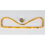 A single row necklace of fifty-five graduated cylindrical vari-coloured mottled butterscotch