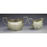 An Edwardian silver oval half-reeded two-handled sugar bowl and matching milk jug, Birmingham 1901