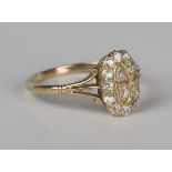 A gold and diamond oval panel shaped cluster ring, mounted with cushion cut diamonds between split