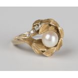A gold, cultured pearl and diamond ring in a foliate design, mounted with a single cultured pearl