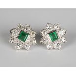 A pair of emerald and diamond nine stone stylized floral cluster earstuds, each mounted with a