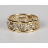 A 9ct gold and diamond set band ring with pierced decoration, mounted with circular cut diamonds,