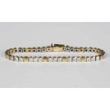 An 18ct two colour gold and diamond bracelet, formed as sections of three diamond set links in