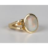 A gold ring, mounted with an oval opal between split shoulders, detailed '18ct', weight 9g, ring