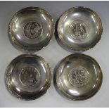 A group of four Hong Kong sterling silver circular dishes, each inset with a one dollar coin, two