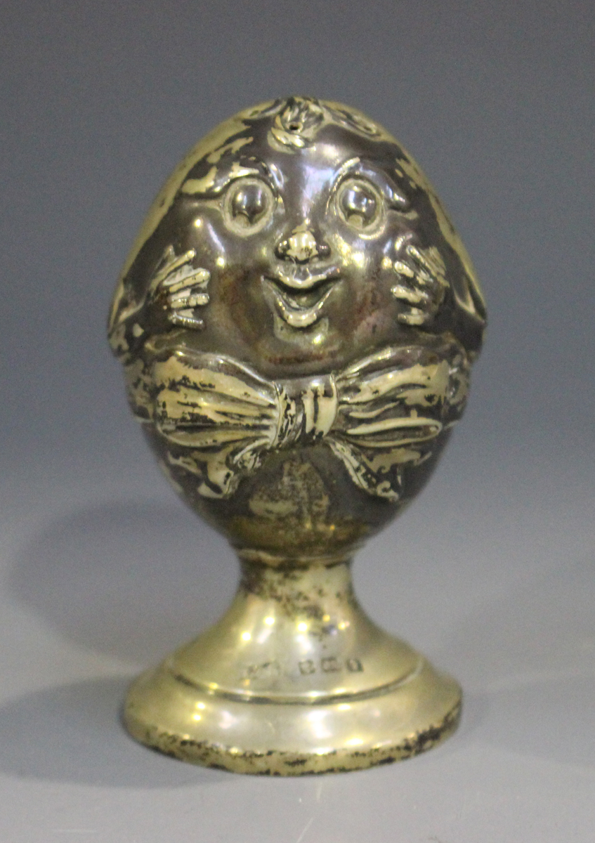 An Edwardian silver novelty pepper caster in the form of 'Humpty Dumpty', on a circular foot,